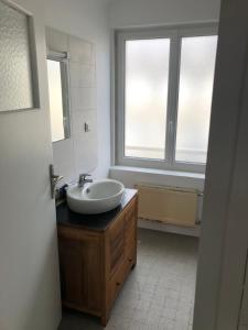 ein Badezimmer mit einem Waschbecken und einem großen Fenster in der Unterkunft FENUA : gite 5 chambres 10 couchages en ville in Valognes