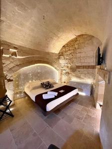 a bedroom with a bed in a stone room at CASA VACANZE BB 164-166 in Matera