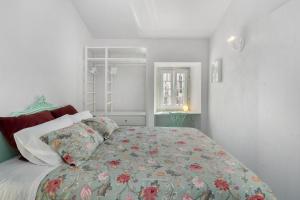 una camera da letto con un grande letto con un copriletto floreale di Wonderland Leiria a Leiria