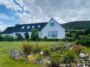 una casa blanca con un jardín delante de ella en "Balmoral View", en Ollach