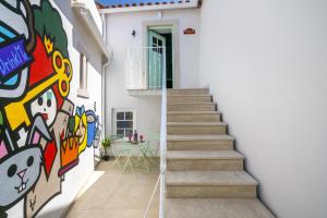 a stairway with a mural on the side of a house at Wonderland House Leiria in Leiria