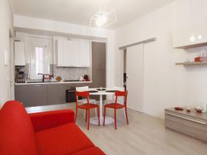uma sala de estar com um sofá vermelho e uma mesa e cadeiras em Modern Central Apartment em Grottammare