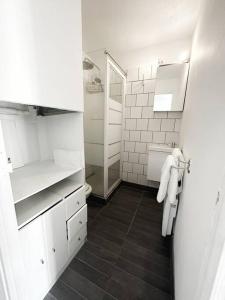 La salle de bains blanche est pourvue d'un lavabo et de toilettes. dans l'établissement T2 front de mer secteur Lydia- Clim, au Barcarès