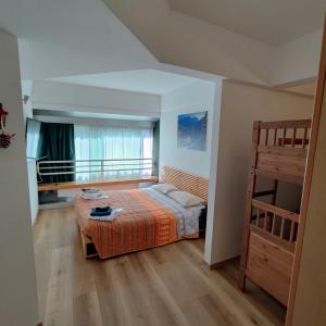 sypialnia z łóżkiem i łóżkiem piętrowym w obiekcie Genziana Apartment w mieście Marilleva