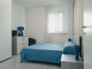 a bedroom with a blue bed and a window at Modern Central Apartment in Grottammare