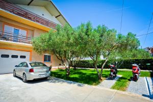 a car and a motorcycle parked in front of a house at Apartmani Roko in Zadar