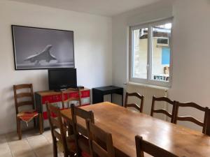 ein Esszimmer mit einem Tisch und einem Delphin auf dem TV in der Unterkunft FENUA : gite 5 chambres 10 couchages en ville in Valognes