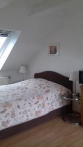 - une chambre avec un lit et une couette à fleurs dans l'établissement Ferienwohnung Sonnenschein, à Bad Harzburg