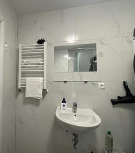 a white bathroom with a sink and a mirror at Erbacher Ferienwohnung 2 in Erbach