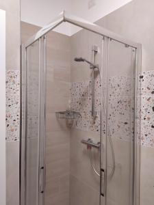 um chuveiro com uma porta de vidro na casa de banho em Modern Central Apartment em Grottammare