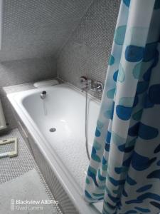 La salle de bains est pourvue d'une baignoire et d'un rideau de douche. dans l'établissement Ferienwohnung Sonnenschein, à Bad Harzburg