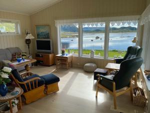 a living room with a view of a lake at Cozy cottage at the Atlantic coast in Leknes