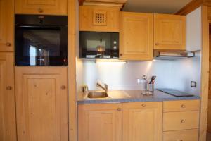 a kitchen with wooden cabinets and a sink at Le Surf 1 in Mussillon