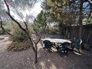 a table and chairs sitting around a table with trees at La Caseta de Cadaqués in Cadaqués