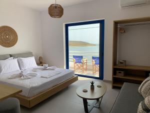 a bedroom with a bed and a view of the ocean at Kythera Beach Apartments in Diakofti