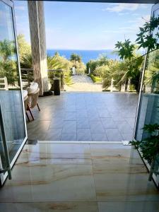 una porta aperta su un patio con vista sull'oceano di Elysium Hotel a Dhërmi