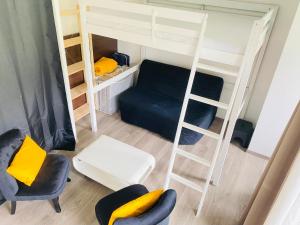 um pequeno quarto com um beliche e um sofá em Studio Piscine Honfleur Deauville em Équemauville