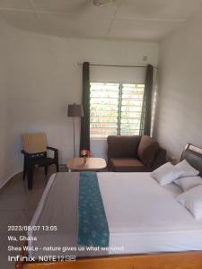 a bedroom with a large bed and a couch at Room with new SAMSUNG AC, private bath and veranda, restaurant facilities in a secured BeautyByNature scenery in Wa