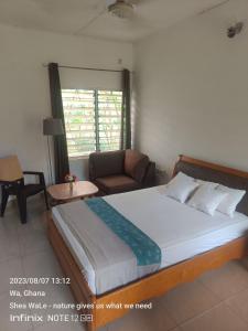 a bedroom with a large bed and a couch at Room with new SAMSUNG AC, private bath and veranda, restaurant facilities in a secured BeautyByNature scenery in Wa