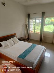 a bedroom with a bed and two windows in a room at Room with new SAMSUNG AC, private bath and veranda, restaurant facilities in a secured BeautyByNature scenery in Wa