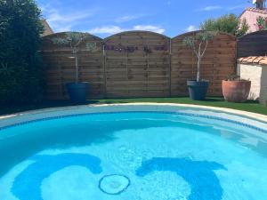 einen Pool mit blauem Wasser im Hof in der Unterkunft Très jolie maison familiale, Piscine Cosy, havre de paix à 10 min des plages in Mauguio