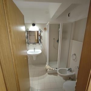 uma casa de banho com um lavatório, um chuveiro e um WC. em Genziana Apartment - CIPAT 22114 em Marilleva
