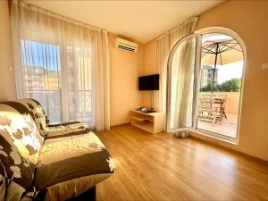 サニービーチにあるMessembria Resort - Menada Apartmentsのリビングルーム(ベッド1台、大きな窓付)