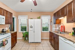 a kitchen with a white refrigerator in the middle at Cozy Retreat, Steps to Yale Bridgeport Hospital in Bridgeport