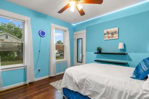 een blauwe slaapkamer met een bed en 2 ramen bij The Blue Room near Yale Hospital/Bridgeport in Bridgeport
