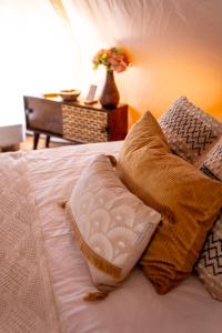 un letto con due cuscini e un vaso di fiori di Glamping Gozdna Jasa a Bovec