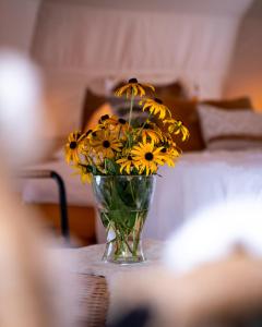 eine Vase gelber Blumen auf einem Tisch in der Unterkunft Glamping Gozdna Jasa in Bovec