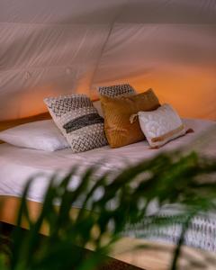 a bed with four pillows on it in a tent at Glamping Gozdna Jasa in Bovec