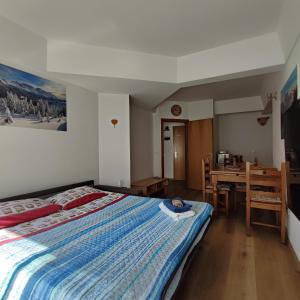 a bedroom with a large bed and a table at Genziana Apartment - CIPAT 22114 in Marilleva