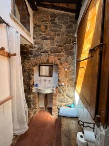 a stone bathroom with a sink in a stone wall at La Cannicciaia in Montale
