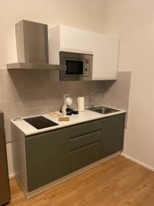 een kleine keuken met een wastafel en een magnetron bij Cucchiari Suite 1A in Modena