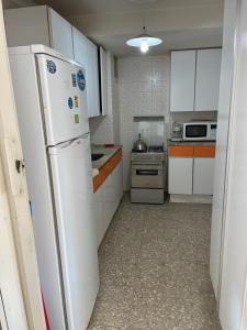 una cucina con mobili bianchi e un frigorifero bianco di Torre de las Americas a Punta del Este