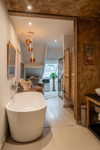 a bathroom with a large tub in a room at La Chambre Rose in Durbuy