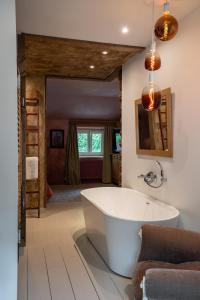 La Chambre Rose في دربي: حمام مع حوض استحمام أبيض في الغرفة
