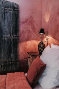 a bedroom with a bed and a table with a lamp at La Chambre Rose in Durbuy