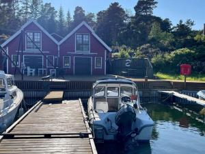 a boat docked at a dock in front of a house at Holiday home MOSTERHAMN V in Mosterhamn