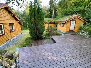 a wooden deck in front of a cabin at Holiday home MOSTERHAMN V in Mosterhamn