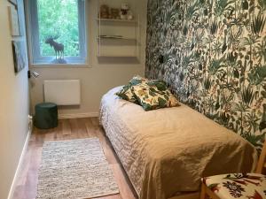 Sandsjöfors的住宿－Holiday home SANDSJÖFORS，一间卧室,配有一张床,窗户上设有鹿
