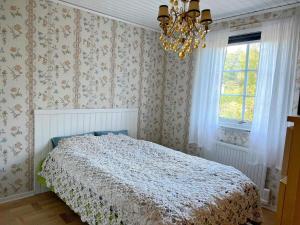 1 dormitorio con cama y lámpara de araña en Holiday home HUDDINGE III, en Huddinge