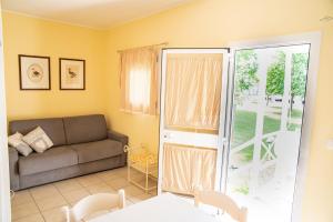 a living room with a couch and a sliding glass door at Bungalow Marina di Cortellazzo in Cortellazzo