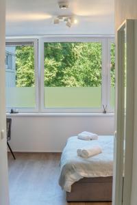 a bedroom with two windows with towels on a bed at Studio Apartment am Kurpark in Bad Segeberg