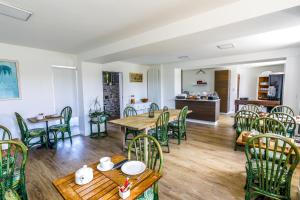 comedor con mesas y sillas de madera en La Villa Bel Air, en Flamanville