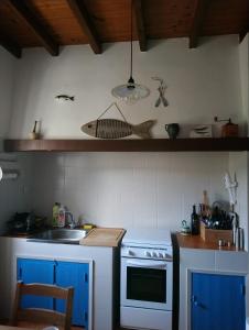 uma cozinha com um fogão azul e um lavatório em Villa Elsa em San Juan de la Arena