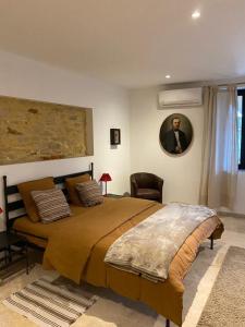 sypialnia z łóżkiem i zdjęciem mężczyzny w obiekcie Bastide de la madeleine w mieście Pougnadoresse