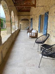 patio z krzesłami i łóżkiem w budynku w obiekcie Bastide de la madeleine w mieście Pougnadoresse