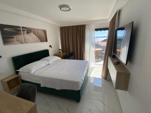 a bedroom with a bed and a television and a balcony at Guest House Ana Residence in Zadar